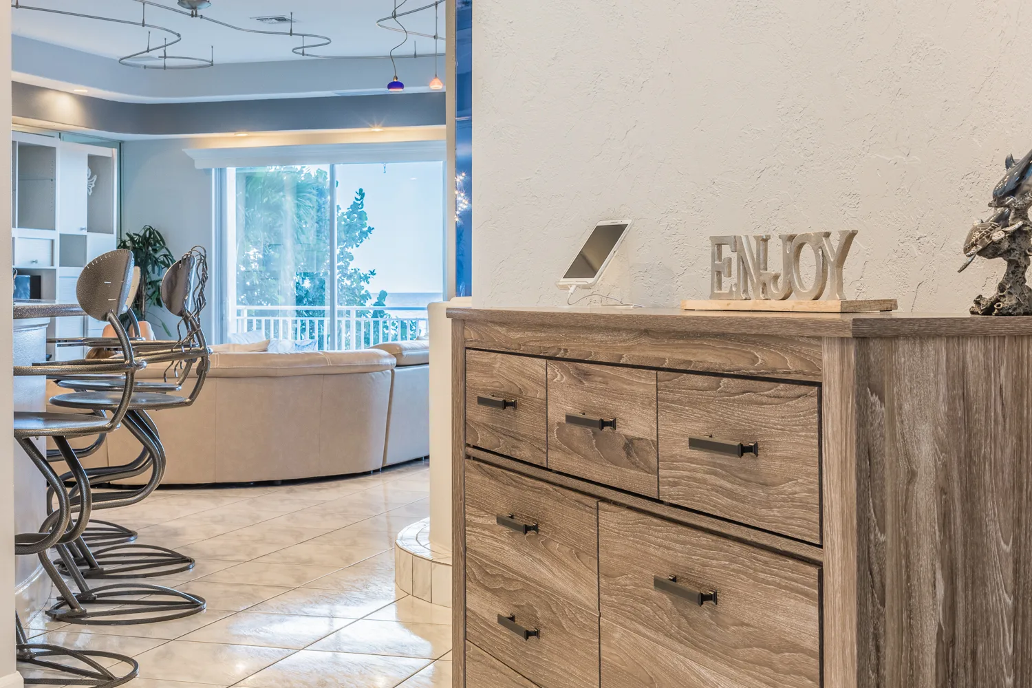 Weathered wood dresser with decorative sign near breakfast bar seating